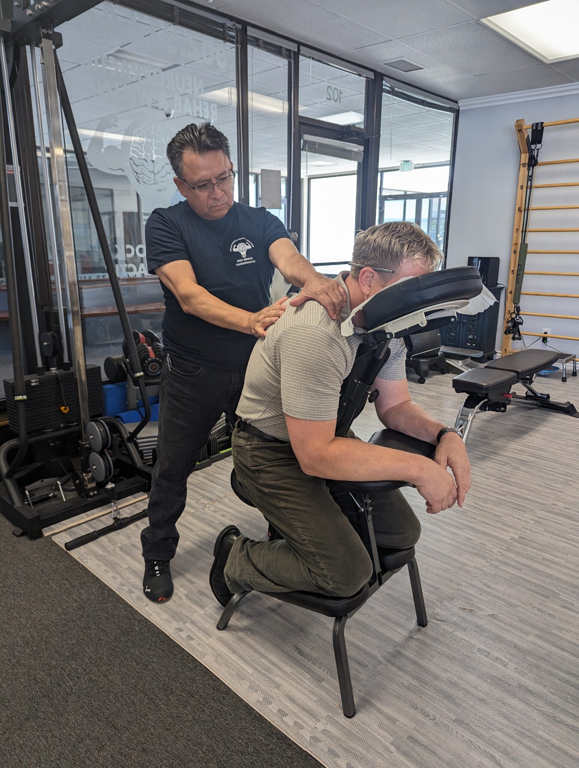 Student Massage Therapist practicing massage techniques on Dr. Brock Johnson